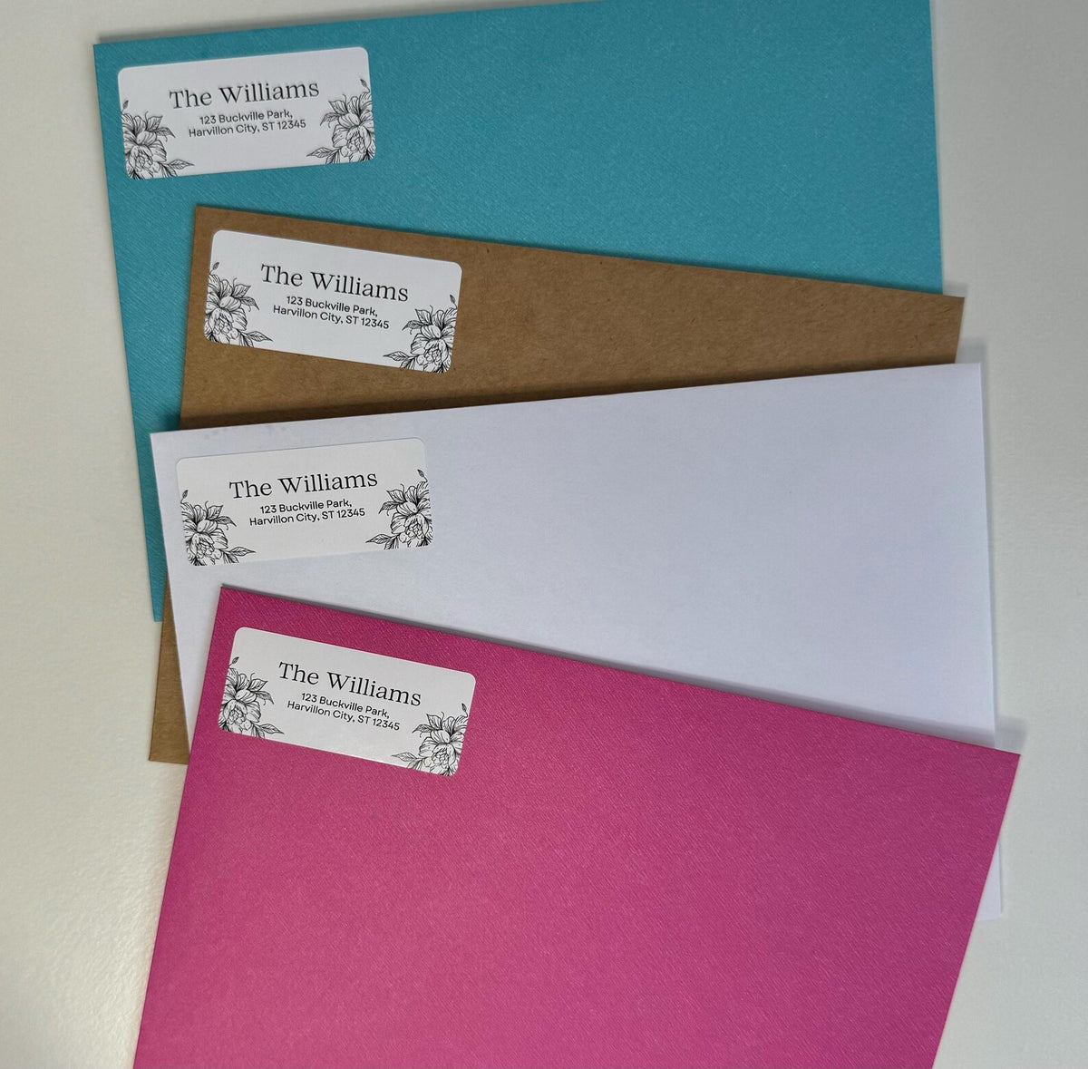 Teal, kraft, white and pink envelopes, each with a floral "The Williams" return address label